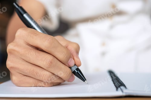 Preview: Young Businesswoman writing something on notebook in office or cafe