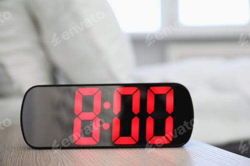 Preview: Digital alarm clock showing 8:00 o'clock on bedside table indoors