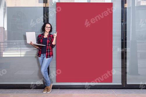 Preview: Photo with copy space of a saleswoman with a laptop while pointing a red banner