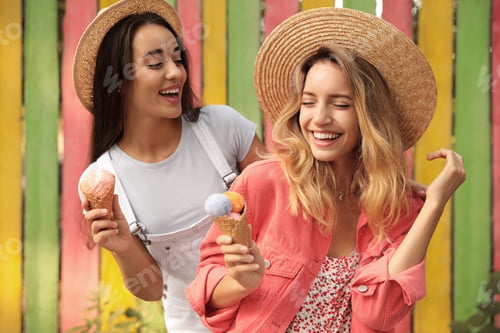 Preview: Young women with ice cream spending time together outdoors
