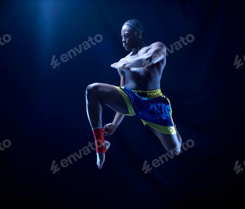 Preview: Studio shot of kick boxer mid air