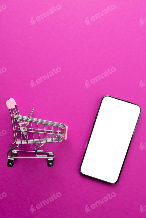 Preview: Composition of shopping cart and smartphone with copy space on pink background