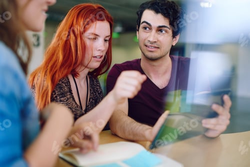 Preview: Unposed group of creative business people in an open concept office brainstorming.
