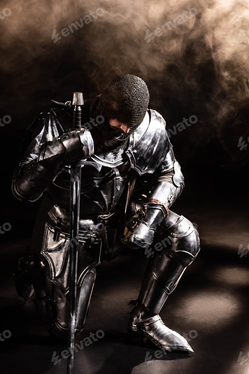 Preview: handsome knight in armor holding sword and bend knee on black background