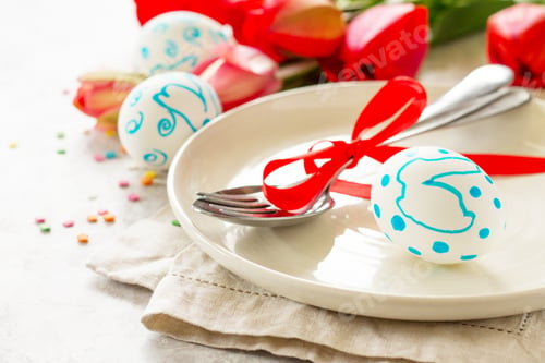 Preview: Easter table setting with tulips flowers, Easter eggs and cutlery.