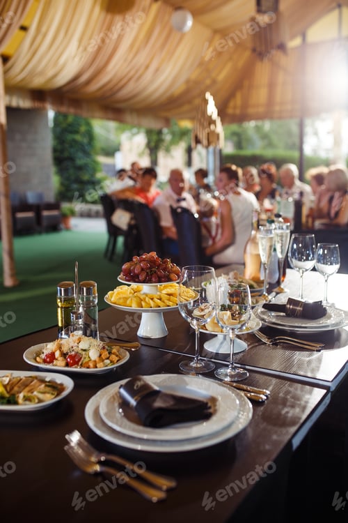 Preview: Sparkling glassware stands on long table prepared for wedding dinner.