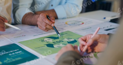 Preview: Closeup group Asia businesspeople talk ESG strategies risk management workshop night.