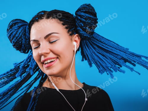 Preview: Gorgeous lady with dyed african braids hairstyle listening music in headphones