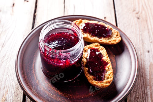 Preview: black currant jam in glass jar and crackers