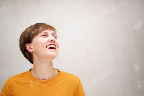 Preview: horizontal portrait laughing young blond woman against white wall