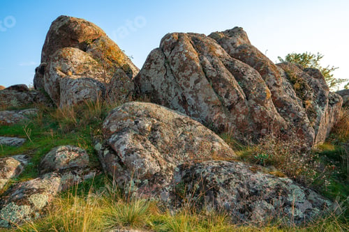 Preview: A small pile of stones in a green-yellow field against the background of a sky in Ukraine