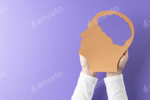 Preview: Composition of hands holding head silhouette with purple brain on purple background, with copy space
