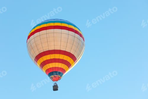 Preview: Colorful hot air balloon flying in blue sky. Space for text