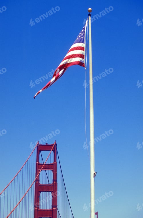 Preview: the United States of America or USA flag on a flagpole on the background of the Golden Gate Bridge