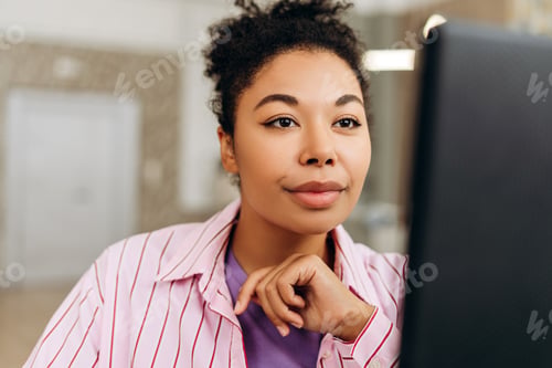 Preview: African American woman office worker concentrating while working on computer