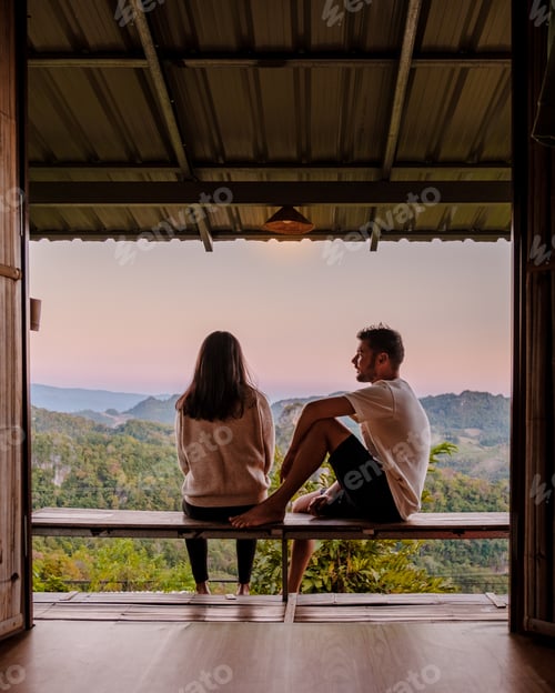 Preview: Couple Relaxing on Porch Overlooking Beautiful Tropical Landscape