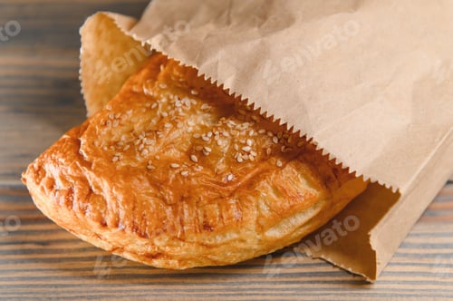 Preview: Puff pastry triangle filled with with jam on a wooden background