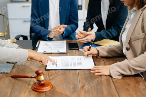 Preview: business people and lawyers discussing contract papers sitting at the table.