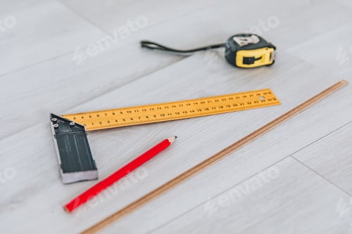 Preview: Collection of Essential Measuring Tools Including a Tri-Square, Ruler, Red Pencil, and Tape Measure