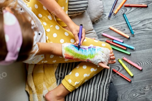Preview: Teen girl with a broken arm at home draws an orthopedic cast