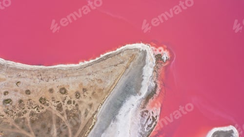 Preview: Flying over a pink salt lake. Salt production facilities saline evaporation pond fields in the salty