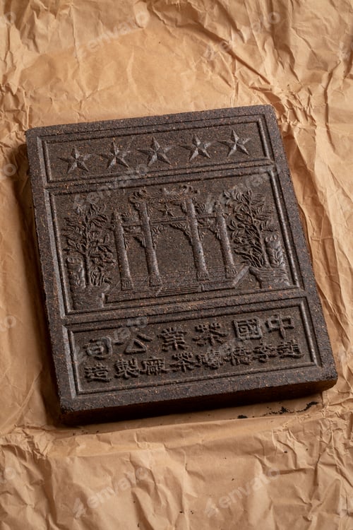 Preview: Unpacked Chinese tea brick from the Hubei Province close up on package paper