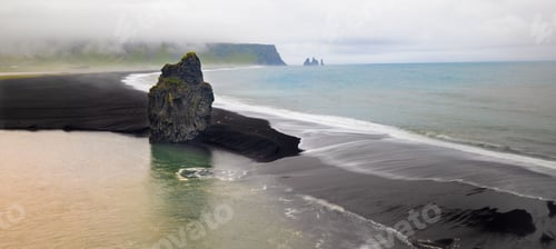 Preview: Scenic view of Dyrholaey black sand beach with unique rock formations.
