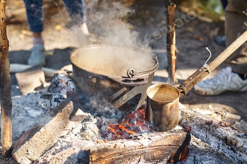 Preview: Close up of boiling pot at rhe campfire on picnic. Hike cooking concept
