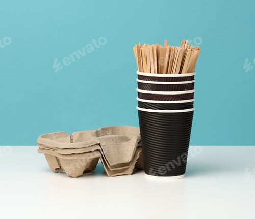 Preview: Stack of brown disposable paper cups and a stand on a white table, blue background