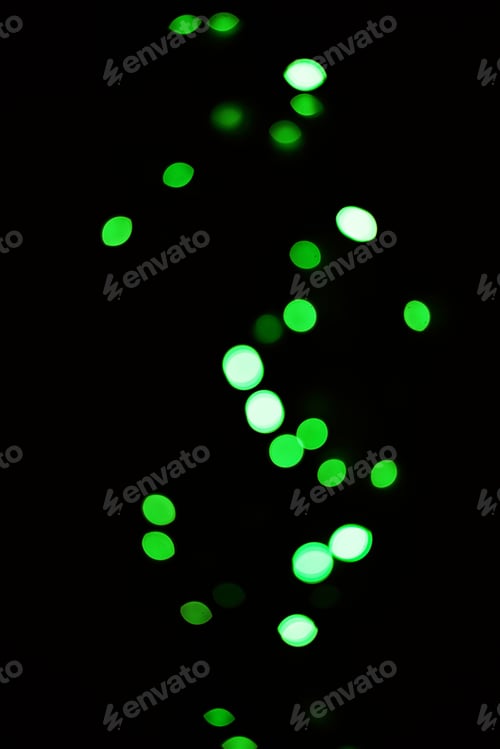 Preview: Green light, bokeh and glow on dark background isolated on a mockup space. Blur, black backdrop and