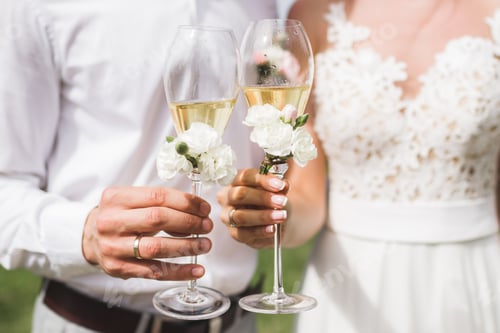 Preview: Couple Toasting Champagne Decorated with White Flowers