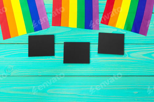 Preview: Bright rainbow gay flag on wooden background and blank space