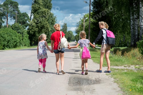 Preview: rear view on happy girls with school bags run and jump on an asphalt footpath road