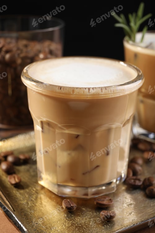Preview: Refreshing iced coffee with milk in glass on table, closeup