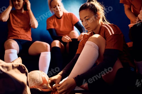 Preview: Young soccer player and her teammates getting dressed in locker room.