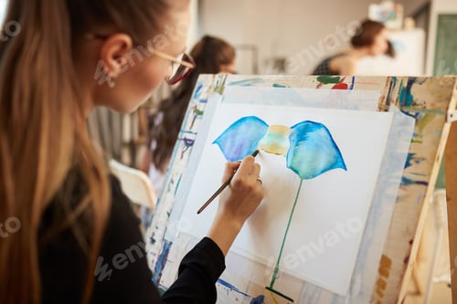 Preview: Woman painting picture on easel in art class