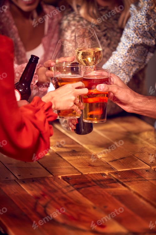 Preview: Close Up Of Friends Enjoying Night Out Drinking In Bar Together Making A Toast