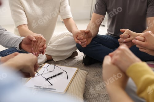 Preview: People holding hands during group psychotherapy session indoors, closeup