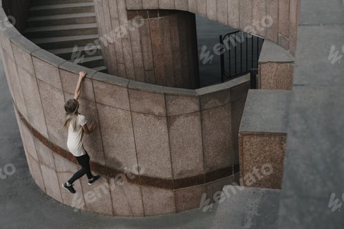 Preview: Young sporty woman doing parkour in city