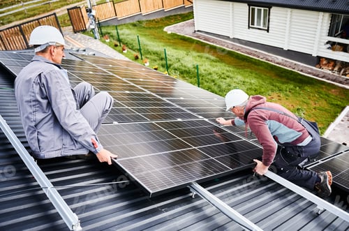Preview: Men workers installing solar panels on roof of house.