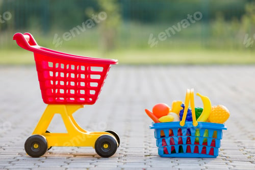 Preview: Shopping pushcart and a basket with toy fruits and vegetables. Bright plastic colorful toys for
