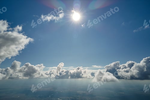 Preview: Aerial view from airplane window at high altitude of earth covered with white puffy cumulus clouds
