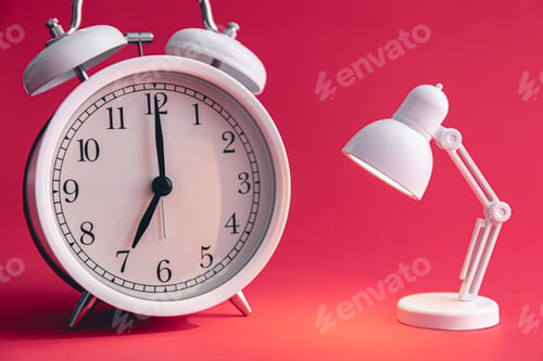 Preview: A white alarm clock and a small toy table lamp on a Viva Magenta background.