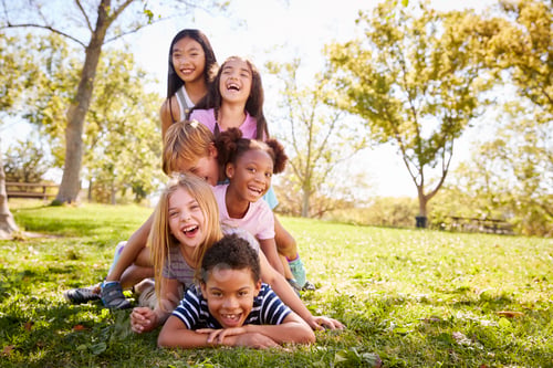 Preview: Multi-ethnic group of children lying in a pile in a park