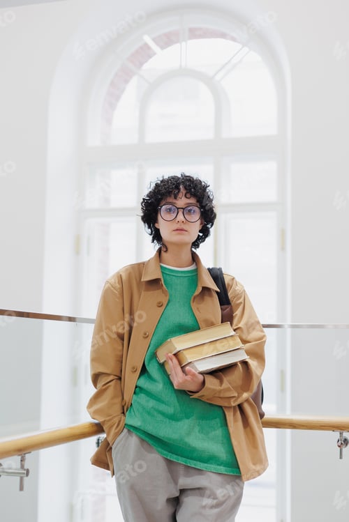 Preview: European student or researcher is reading a book in a library or coworking. study online or work