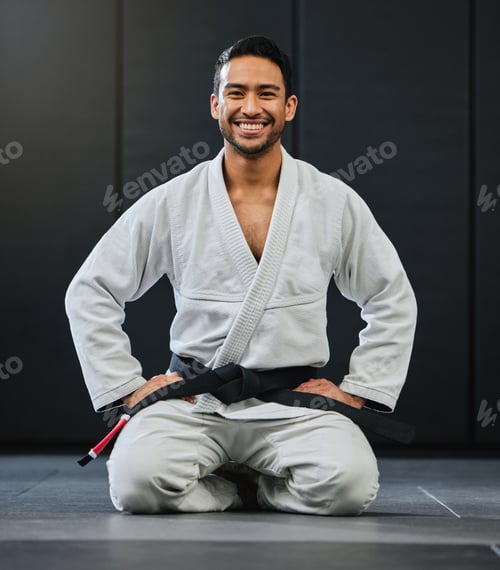 Preview: Mma, karate and training with a young man kneeling in a gym, health studio or dojo in his gi or uni