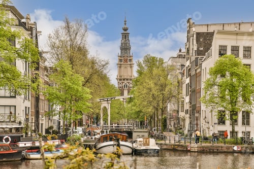 Preview: a canal in amsterdam with boats and a church