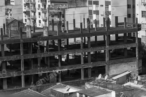 Preview: Monochrome shot of a large construction site with numerous unfinished buildings.