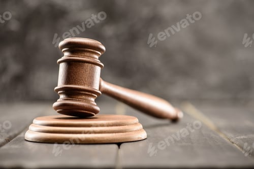 Preview: Close-up view of brown mallet of judge on wooden table on grey, law concept