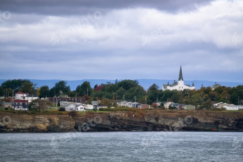 Preview: Residential homes on a rocky coast during a cloudy day